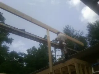Carpenter setting a ridge beam over a new addition frame — Ice Dam Removal by Roofing Brothers in Seven Springs