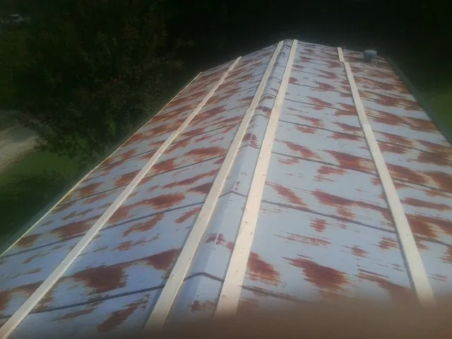 Rusted metal roof panels with new wood purlins before replacement — Storm Damage Roof Repair in Seven Springs by Roofing Brothers